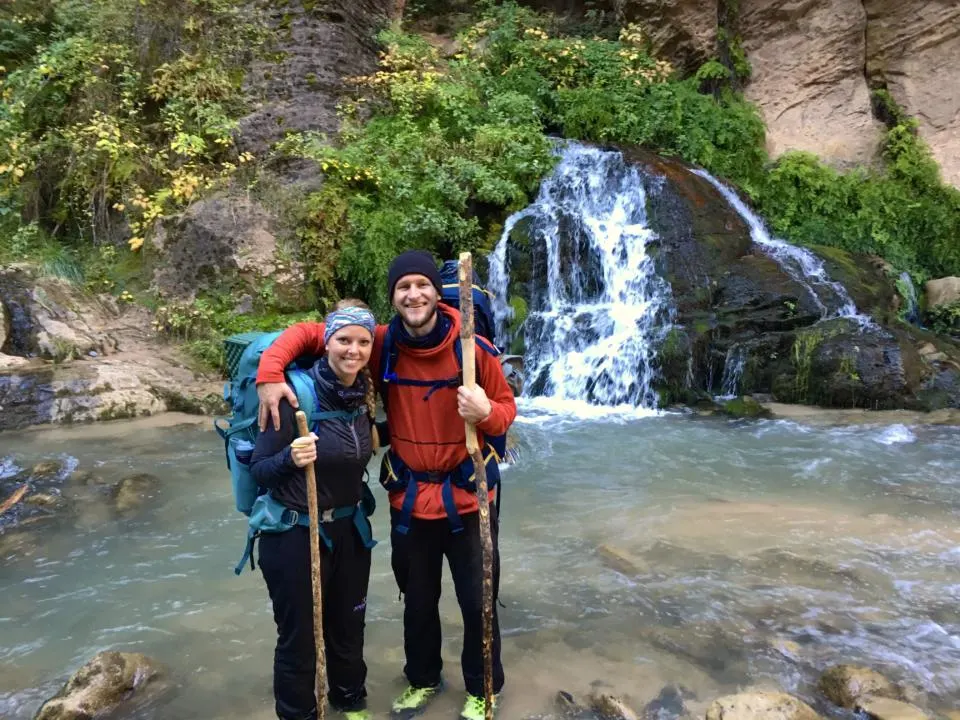 Jake and Emily standing in front of Big Springs with their backpacking gear.