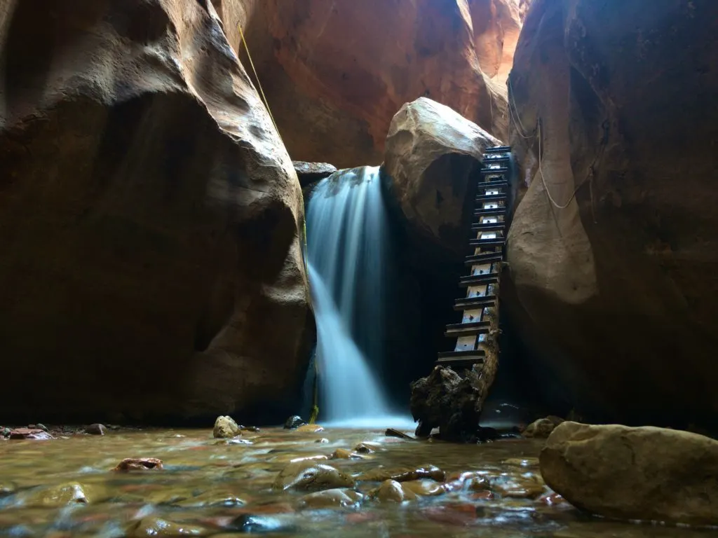 a long-exposure view of the water fall & man-made log ladder in Kanarra Creek which is one of the coolest slot canyons in Utah