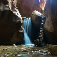 a long-exposure view of the water fall & man-made log ladder in Kanarra Creek which is one of the coolest slot canyons in Utah