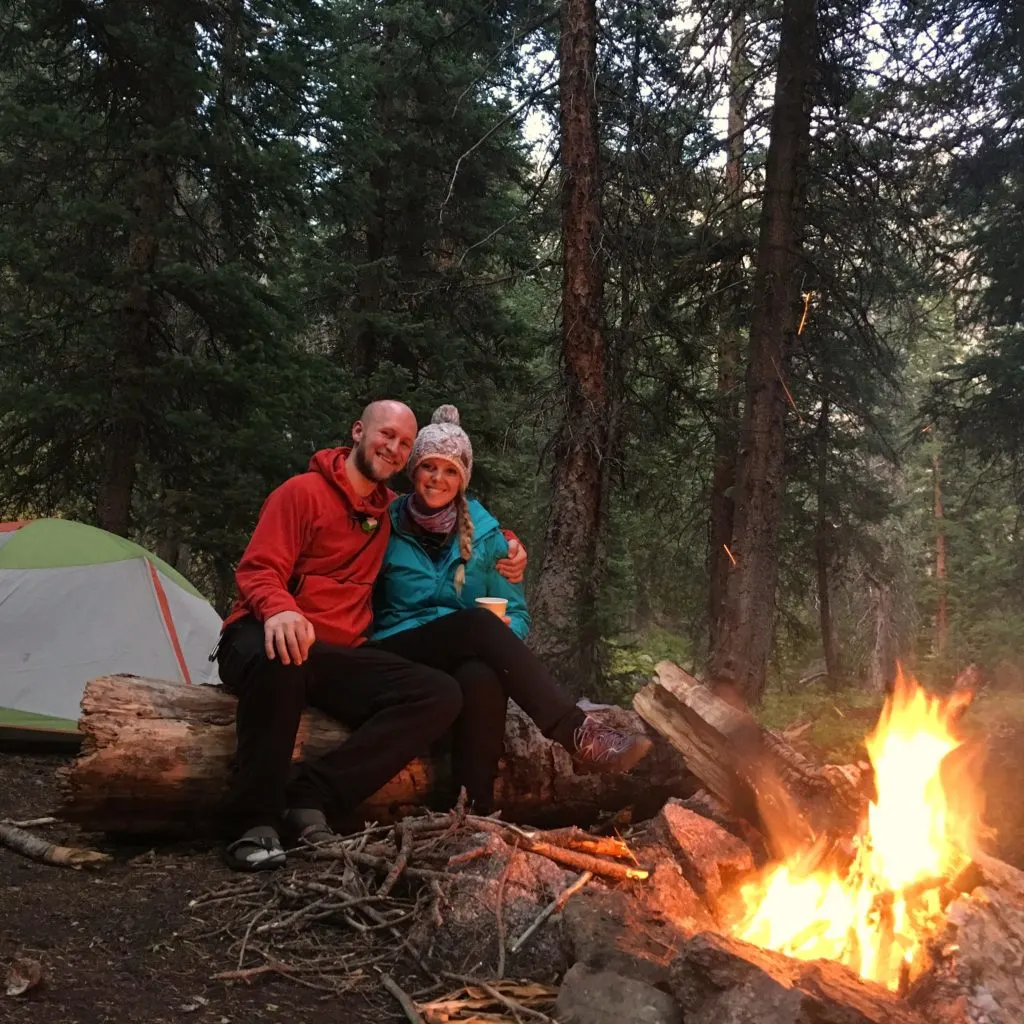 Jake and Emily sitting at a campfire on a backpacking trip