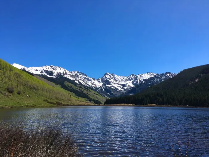 snow covered mountains behind Piney Lake which is one of the best things to do in vail in summer