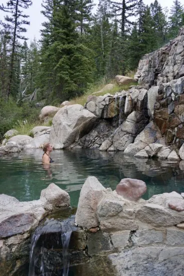 a girl soaking at upper pool at Strawberry Park Hot Springs which is one of the best things to do in Steamboat Springs