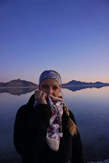 a girl wearing a neck buff at the Bonneville salt flats showing a great gift idea for hikers and backpackers