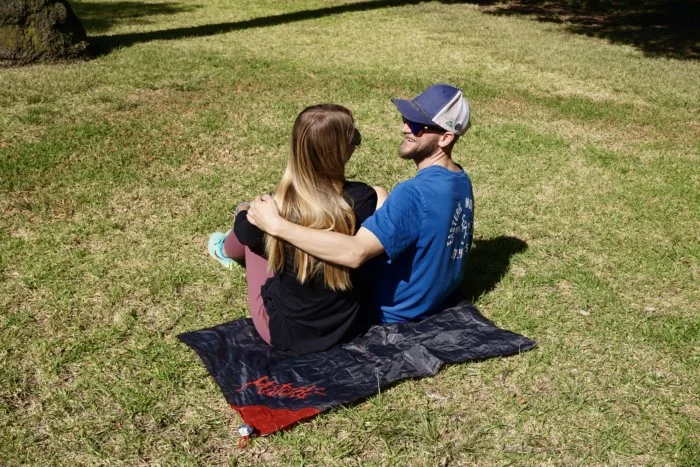 a couple sitting on the Matador pocket blanket which is one of the best gift ideas for hikers and backpackers