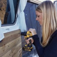 Emily drilling the rustic wooden plank walls on the camervan doors