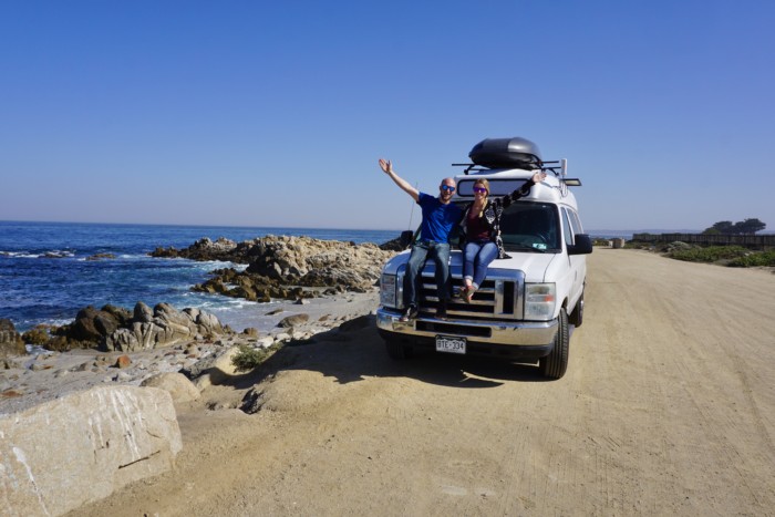 a couple sitting on top of a campervan hood, showing an example of exploring the California coast as a "retired" couple, which is an example of why people do #vanlife