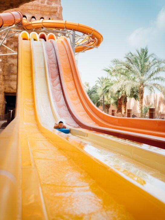 a kid sliding down a waterpark slide, which is a great place to shower on the road and have a little added fun