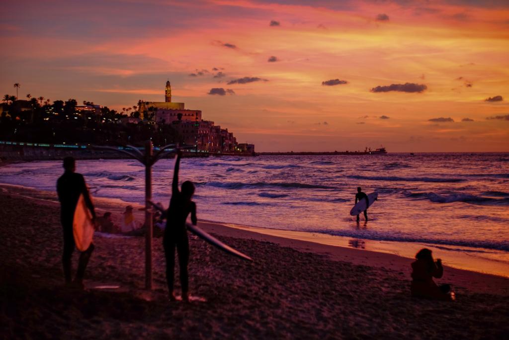 a group of surfers showering off at sunset, which is often one of the places to shower that is overlooked when traveling on the road.