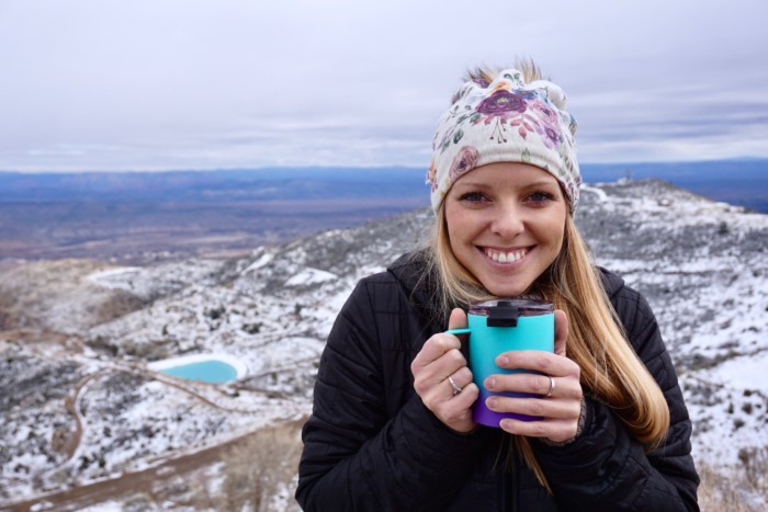 Emily enjoying hot coffee on a hike, offering one of the best vanlife gift ideas