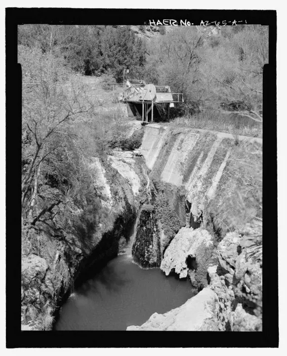 A historic black and white photograph of Fossil Creek Dam.
