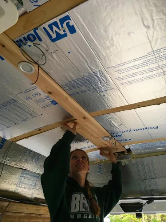 Emily installing the first coupe rows of cedar ceiling