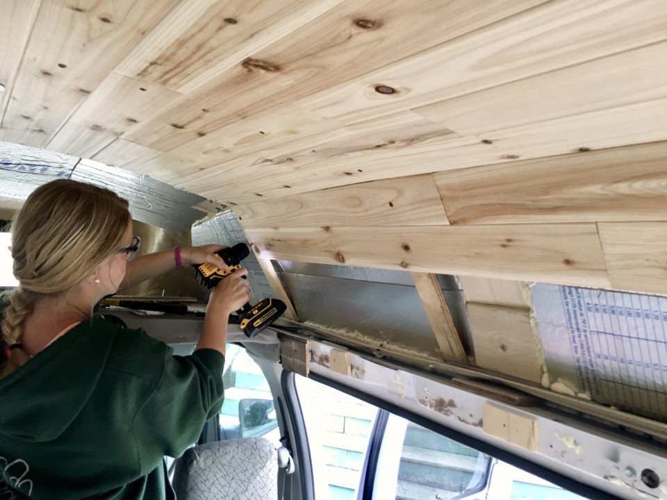 Emily drilling in pieces of our cedar ceiling tongue and groove