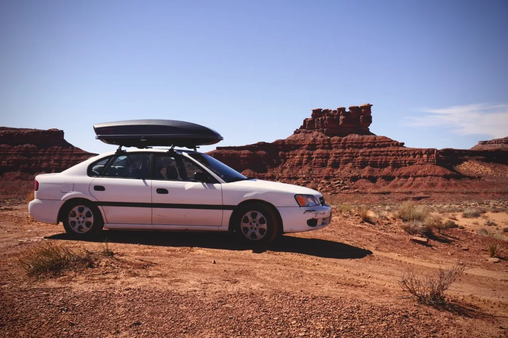Car in the desert with ski cargo box on top