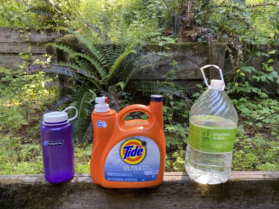 Lined up is a Nalgene bottle, laundry detergent bottle and water jug to show the different bottles someone can urinate in for vanlife