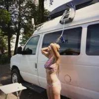 Emily showering outside our van with a solar shower