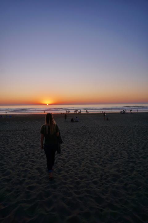 Emily walking on the sand at sunset at Ocean Beach in San Francisco