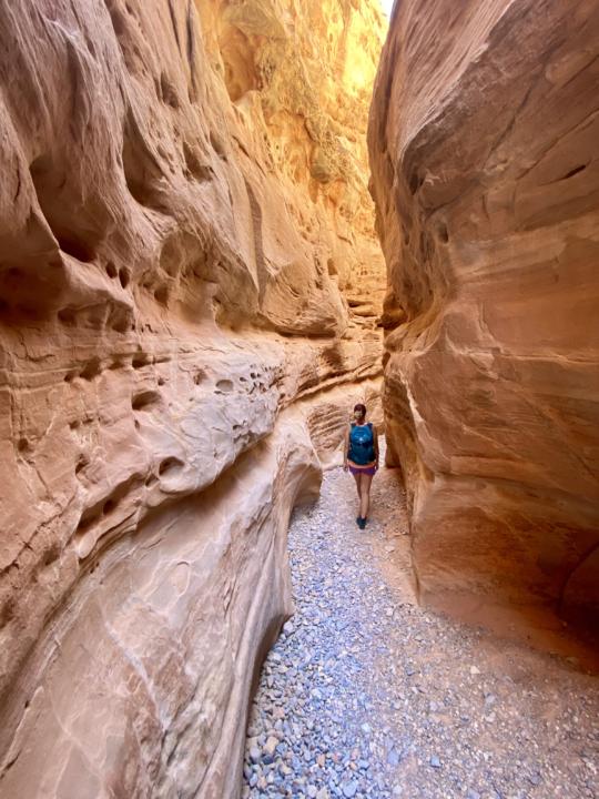 Emily walking in slot canyon on white domes trail in valley of fire state park
