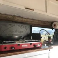Camp Chef Everest on the counter of a campervan representing its ability to be one of the best camper stoves for campervans