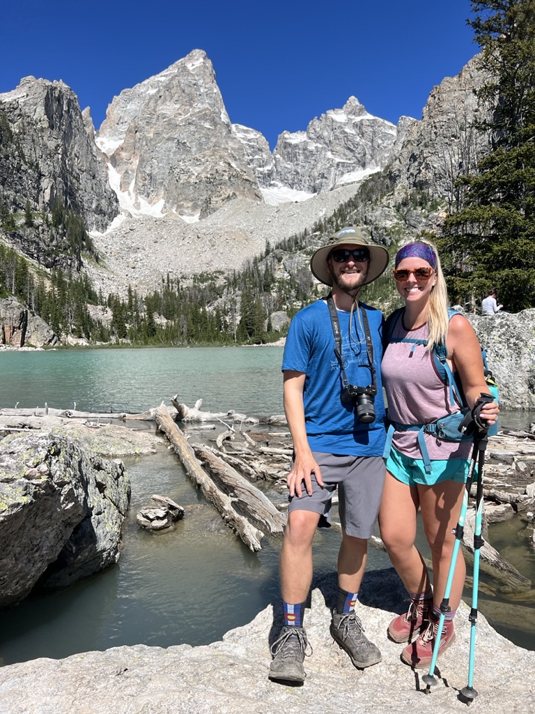 the Two Roaming Souls (Jake & Emily) standing in front of Delta Lake in Grand Teton National Park