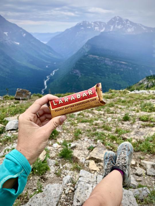 Emily holding a Larabar which is one of the best hiking snacks to fuel your next adventure
