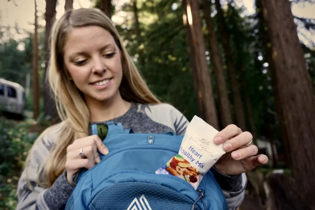 a girl pulling hiking snacks from her backpack