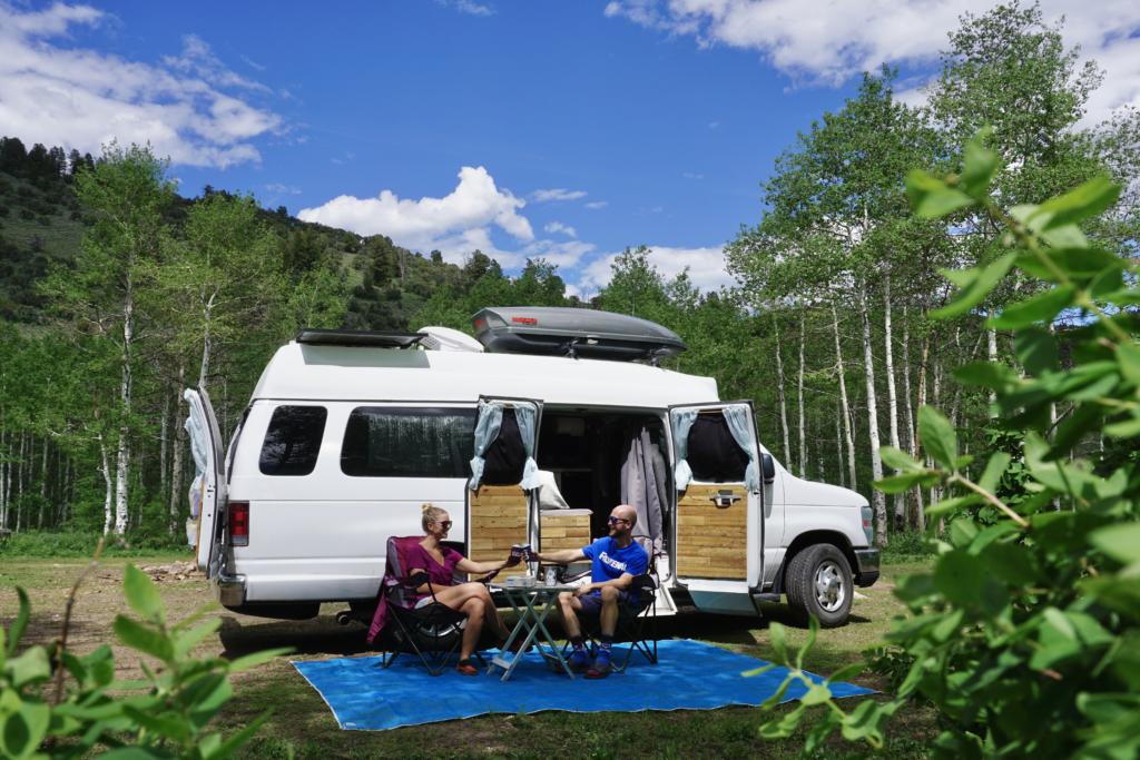 CGear Sand-Free Mat with a couple cheersing in front of their campervan, representing one of the best van life gifts 