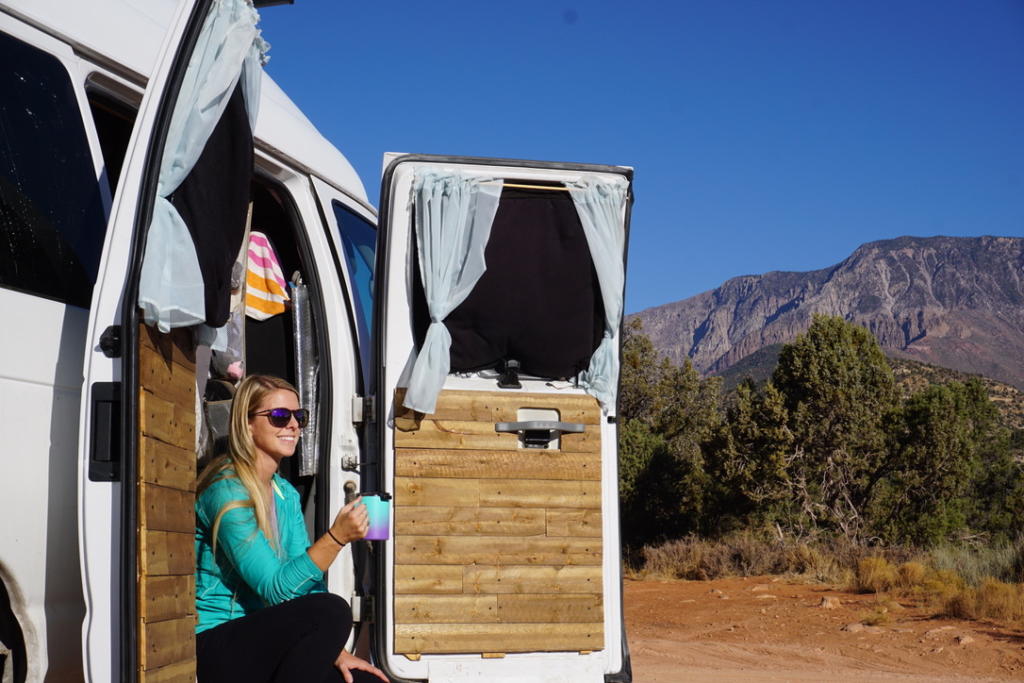 Emily enjoying a cup of coffee after learning how to make the best cup of coffee in vanlife
