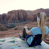 Emily sitting in a crazy creek chair taking in the beautiful red and white wall at Snow Canyon State Park
