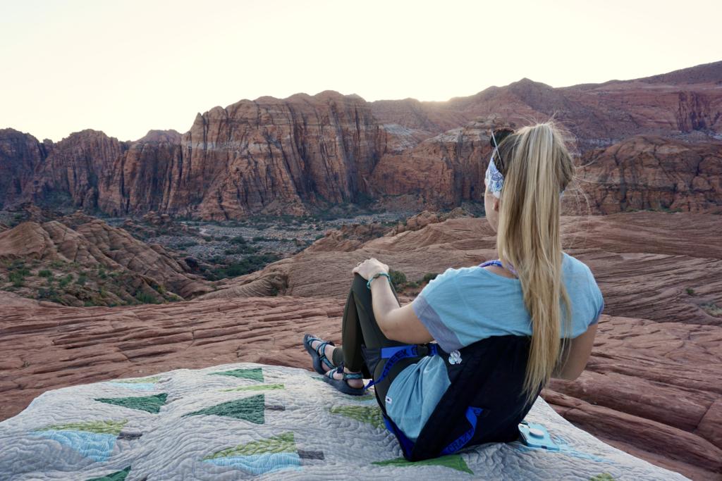 Emily sitting in a crazy creek chair taking in the beautiful red and white wall at Snow Canyon State Park