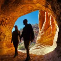 Jake and Emily holding hands with the Sand Caves in the background