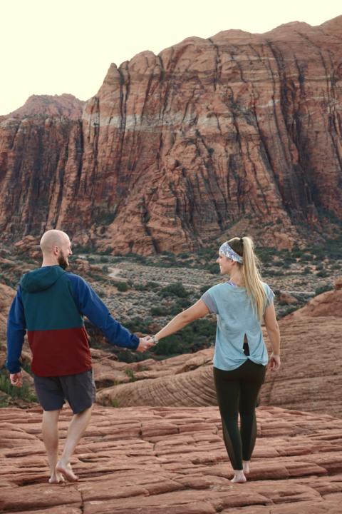 Jake and Emily walking hand in hand atPetrified Dunes at Sunset in Snow Canyon State Park