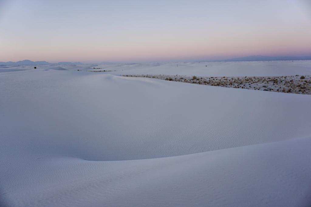 White Sands National Park at sunset with the creamy like sand and pink colors in the distance