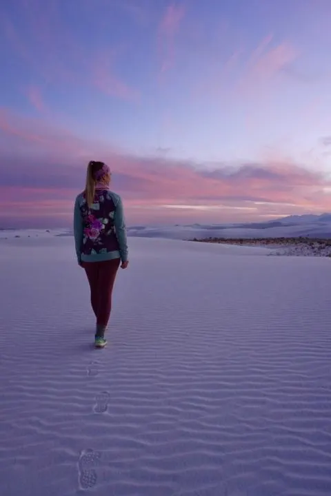 a girl walking on textured white sand in White Sands National Park