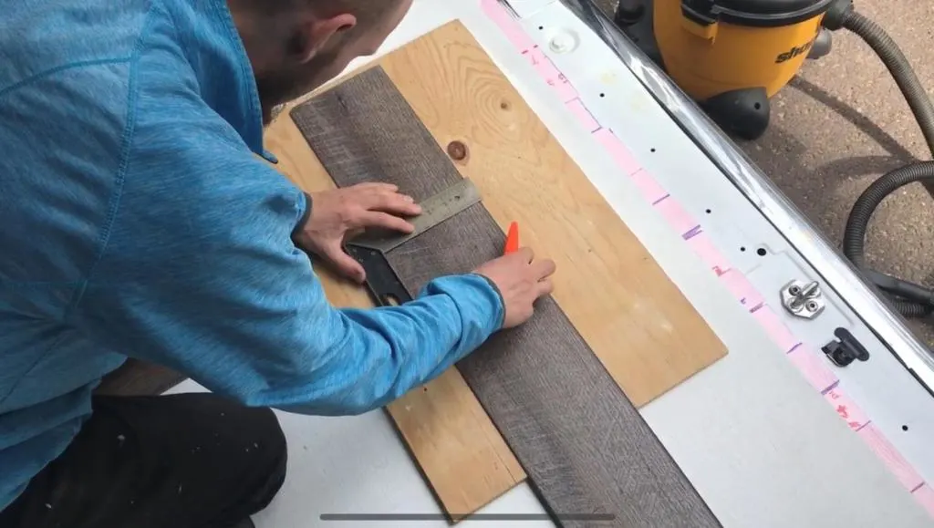 Jake Measuring The Vinyl Floor Planks To Make A Cut