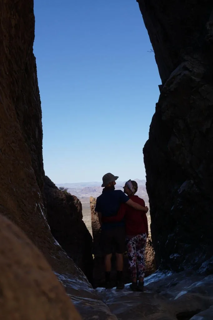 Jake and Emily standing in "the window" which is a split in a canyon with a view down to the valley floor