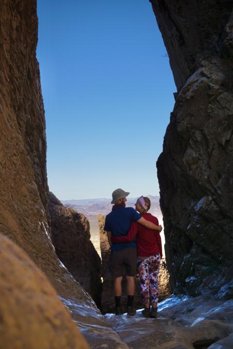 Jake and Emily standing in "the window" which is a split in a canyon with a view down to the valley floor