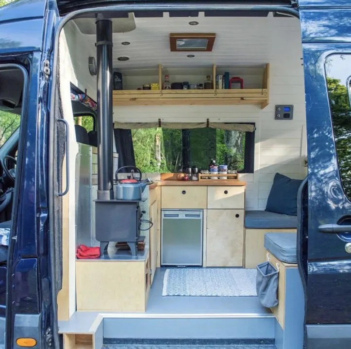 A campervan with a cab partition that forms the wall for part of the kitchen