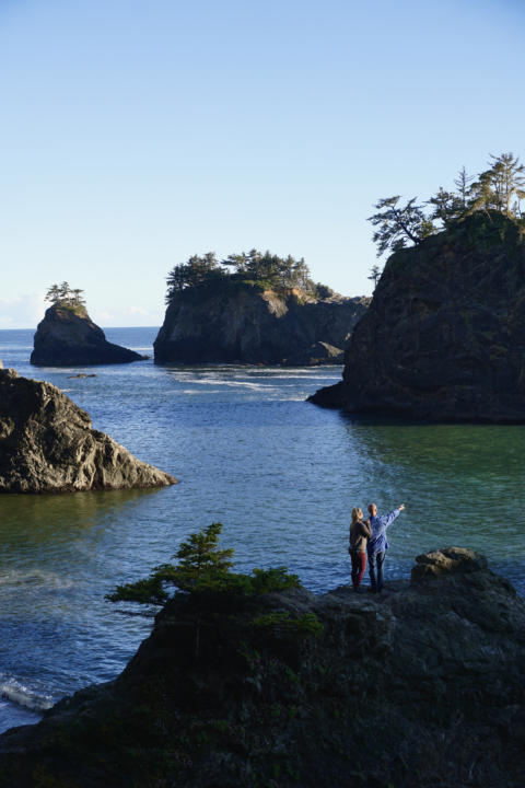 Jake and Emily, the Two Roaming Souls, posing for a photo at Secret Beach on Oregon's Southern Coast.