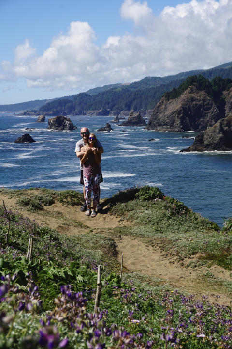 Jake and Emily, the Two Roaming Souls, posing for a picture at Indian Sands Trail in Oregon.
