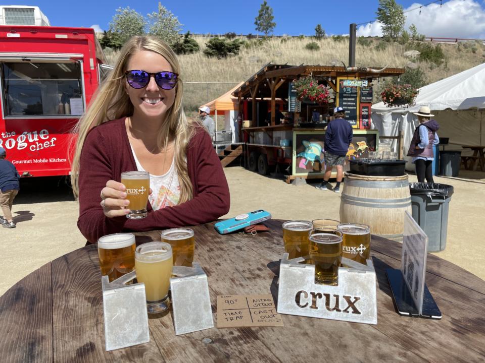 Emily holding her flight of beer at Crux Fermentation Project which could be added to your self-guided brewery tour in Bend