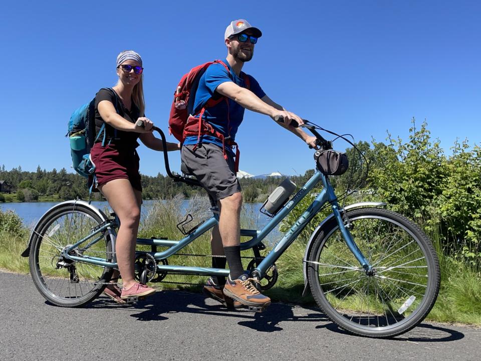 Jake and Em riding a tandem bike on our self-guided brewery tour in Bend