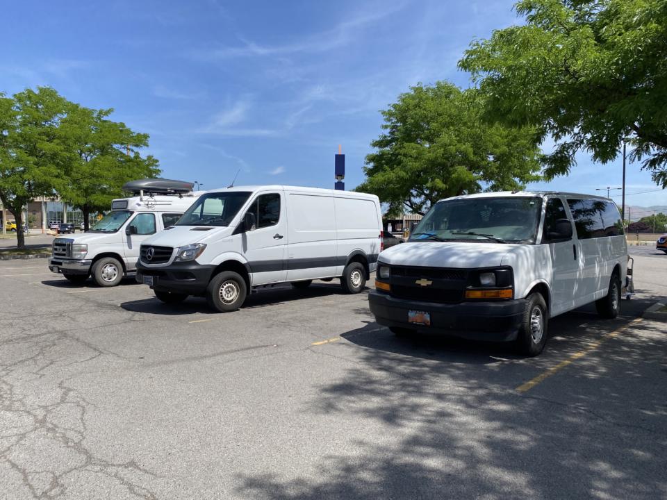 A Chevy Express, Mercedes Sprinter, and Ford E-350. A lineup of vans in a parking lot.