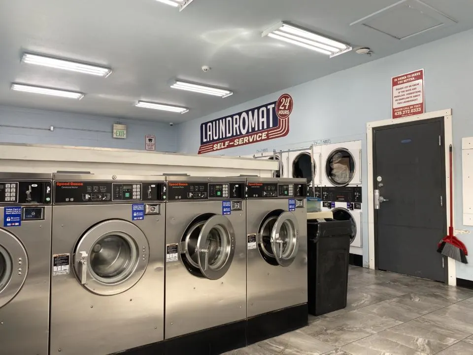 a picture of 3 washers at a laundromat, which is a way to do laundry on the road