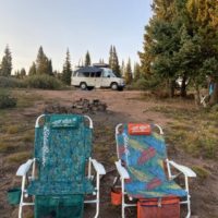 a picture with a van, hammock, awning, camp chairs, etc which are all great camper van accessories