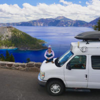 Emily sitting on a campervan, showing one of the best stops along this Oregon Road Trip Guide