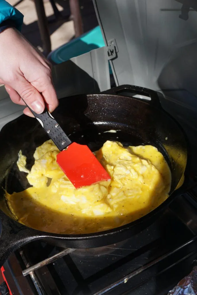Emily using the Sun Company's ClickWare  Modular Titanium Utensils for cooking eggs in the morning on a cast iron skillet