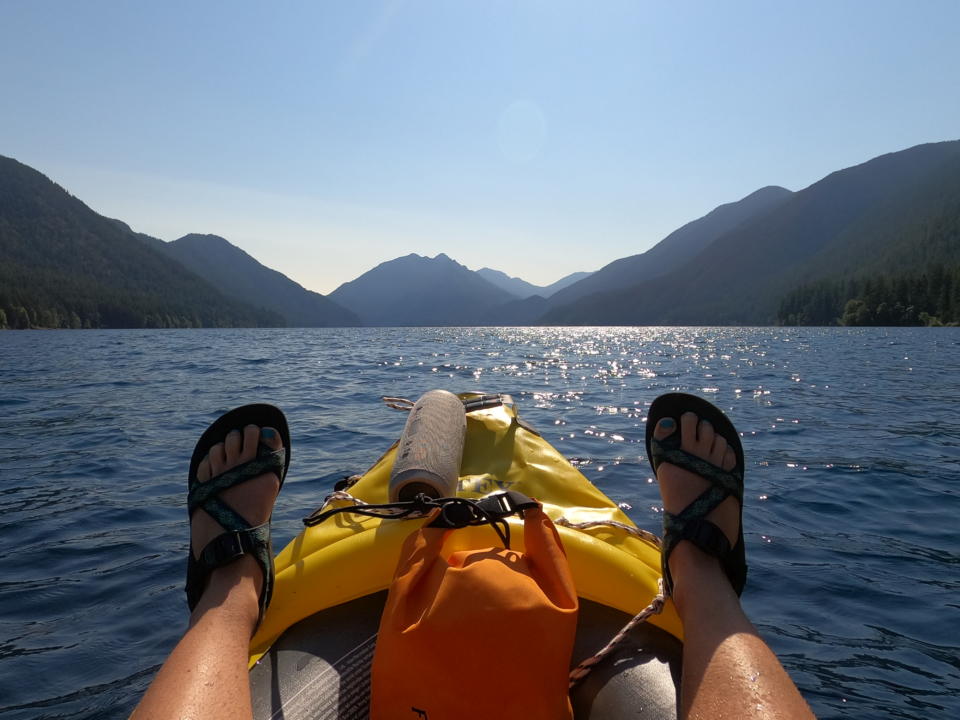 Emily's feet up on the side walls of our Intex Kayak at Lake Crescent in Olympic National Park which is along a Washington Road Trip