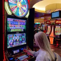 Emily playing a Wheel Of Fortune slot machine on the Sky Ute Casino Floor.