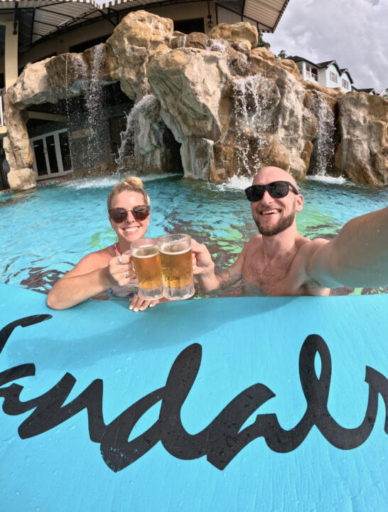 Jake and Emily cheersing 2 piton beers in the pool at Sandals Regency La Toc