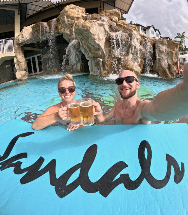 Jake and Emily cheersing 2 piton beers in the pool at Sandals Regency La Toc